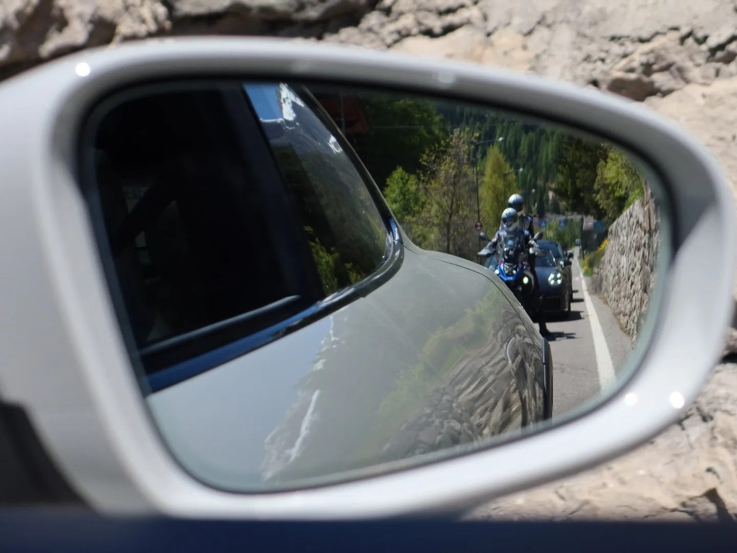 Riders reflected in a Porsche wing mirror on Passo Gardena, Dolomites